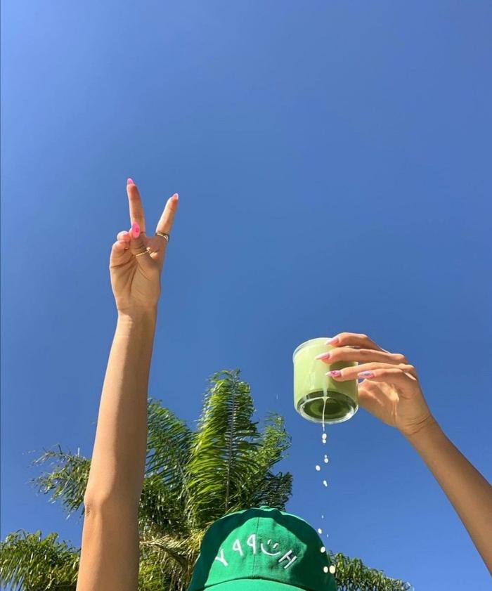 Glas matcha wordt proostend omhoog gehouden